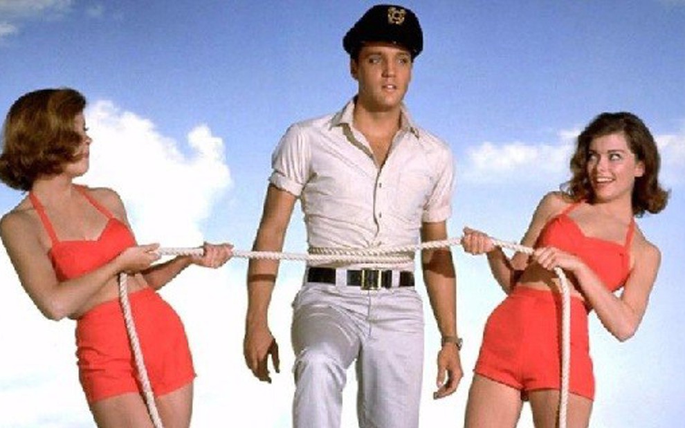 Elvis Presley em cena de Garotas e Mais Garotas (1962) com suas duas pretendentes - Reprodução