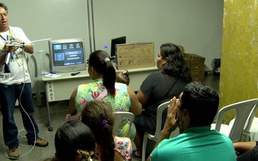 Técnico mostra funcionamento de TV digital para moradores de comunidade do Rio de Janeiro - Reprodução/TV Globo