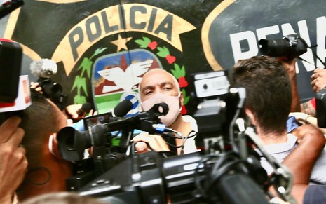 De máscara, Belo é cercada pelo imprensa na saída da cadeia