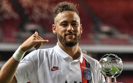 Neymar sorri e mostra troféu de melhor jogador, conquistado na última partida do PSG na Champions League