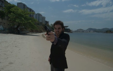 O ator Fiuk, com uma arma na mão, em cena como Ruy em A Força do Querer