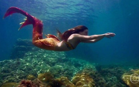 A atriz Isis Valverde nada em um aquário com um rabo de sereia na pele de Ritinha da novela A Força do Querer
