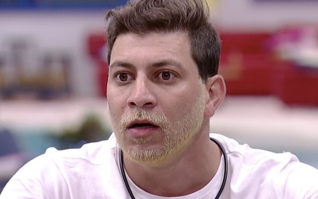 O participante do BBB21 Caio Afiune olha com cara de bravo no Big Brother Brasil 2021, da Globo