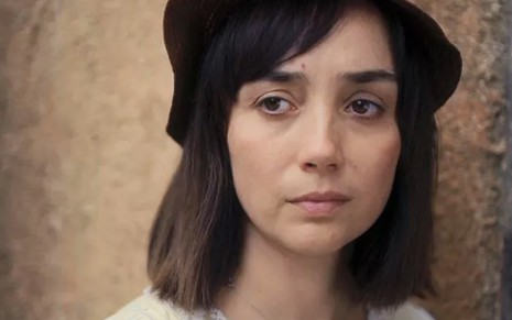 A atriz Simone Spoladore, em close, com um pequeno chapéu, caracterizada como a Clotilde em cena de Éramos Seis