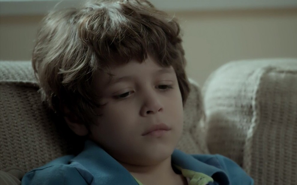 João Bravo em cena de A Força do Querer: triste, criança olha para baixo com cara de choro