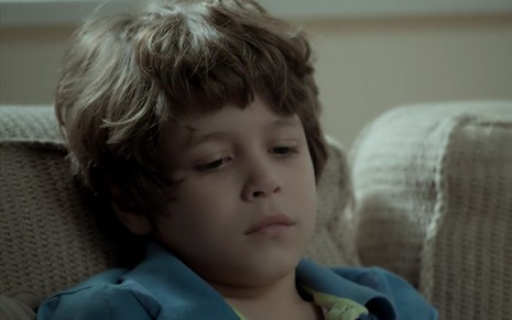 João Bravo em cena de A Força do Querer: triste, criança olha para baixo com cara de choro