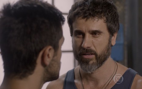 Eriberto Leão em cena com regata azul e expressão emocionada olhando para Felipe Simas como Gael e Cobra