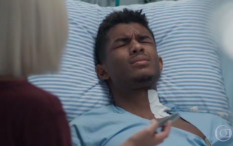 O ator Juan Paiva, em uma cama de hospital, como Anderson, em Malhação - Viva a Diferença