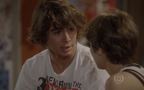Rafael Vitti grava com camiseta branca estampada e olhos marejados conversando com Isabella Santoni, como Pedro e Karina