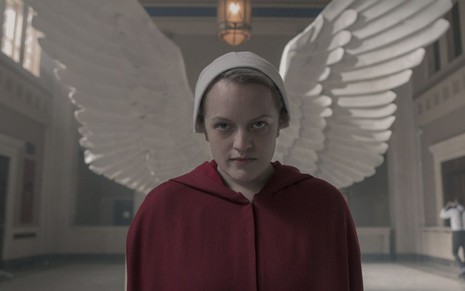 A atriz Elisabeth Moss posa na frente de asas de anjo em foto de divulgação de The Handmaid's Tale