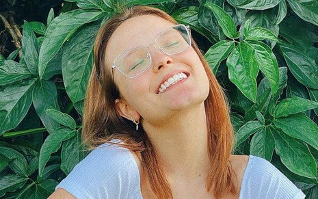 A atriz Larissa Manoela sorri usando óculos de grau e cabelo solto