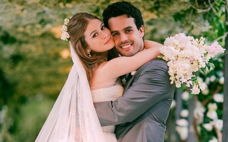 Marina Ruy Barbosa e Alexandre Negrão abraçados na cerimônia de casamento deles com ela de noiva e ele de terno