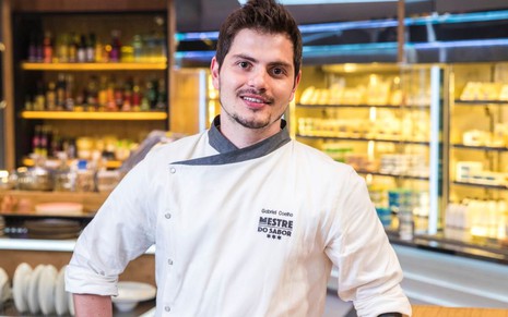 O chef Gabriel Coelho sorri para foto tirada no cenário do Mestre do Sabor, na Globo