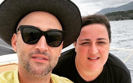 Paulo Gustavo de chapéu e óculos escuros ao lado da irmã, Ju Amaral, posam para selfie em um barco