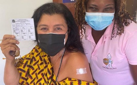 Regina Casé mostra o braço após receber vacina contra a Covid-19 ao lado de profissional de saúde