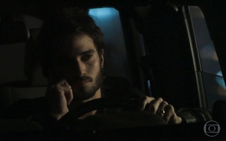 Ruy (Fiuk) dentro do carro falando ao telefone em cena de A Força do Querer
