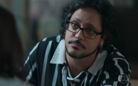 Roney (Lucio Mauro Filho) com uma camisa listrada preta e branca em cena de Malhação - Viva a Diferença