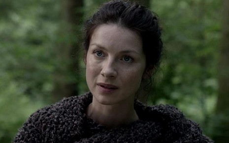 Caitriona Balfe com expressão séria em cena como Claire Fraser em Outlander