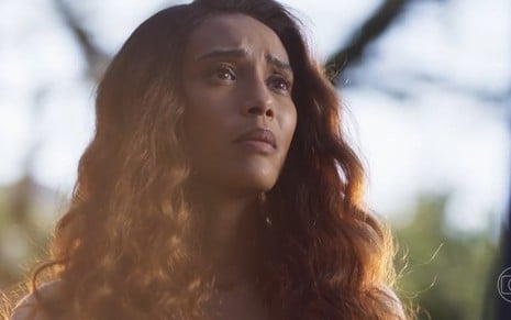A atriz Taís Araujo com expressão triste em cena externa de Cara e Coragem