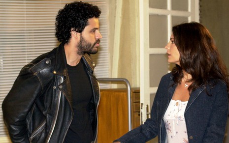 Os atores Bruno Garcia e Helena Ranaldi como Pedro e Clara em Coração de Estudante; eles estão de lado, se olhando frente a frente com cara séria