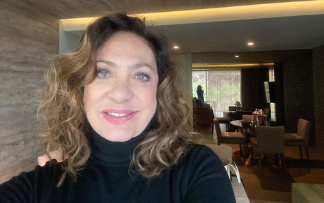 Eliane Giardini usa blusa preta e faz uma selfie