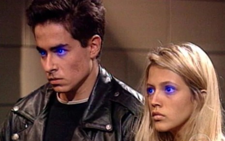 Felipe Folgosi e Patrícia de Sabrit estão com expressão séria e com uma luz azul nos olhos em cena da novela Olho no Olho (1993)