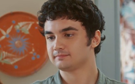 Gabriel Contente com expressão séria em cena como Tatá na novela Vai na Fé