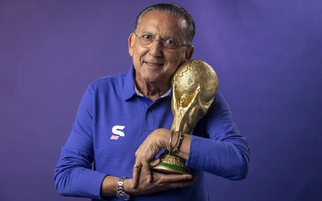 Galvão Bueno sorri e segura a taça da Copa do Mundo