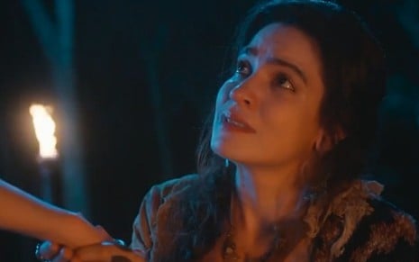 Cigana Lyra (Maria Manoela) está em acampamento durante à noite em cena de Além da Ilusão