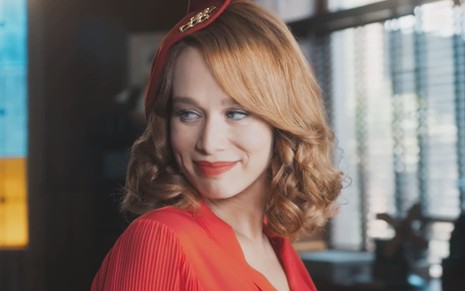 Mariana Ximenes caracterizada como Gilda em Amor Perfeito; ela usa os cabelos ruivos na altura dos ombros e um batom vermelho bem marcado