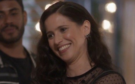 Mel Lisboa grava cena sorrindo, como Regina em Cara e Coragem