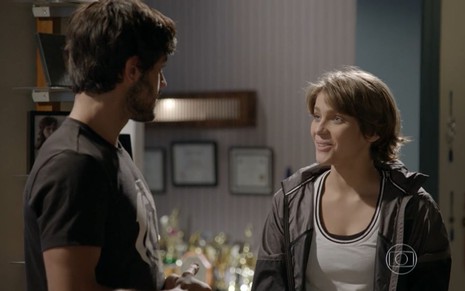 Isabella Santoni grava cena sorrindo para Felipe Simas, que aparece de costas para a imagem, como Karina e Cobra