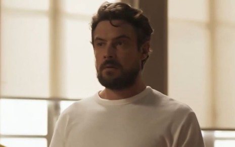 Sergio Guizé em cena de Mar do Sertão; ator usa uma camisa branca e tem o semblante sério