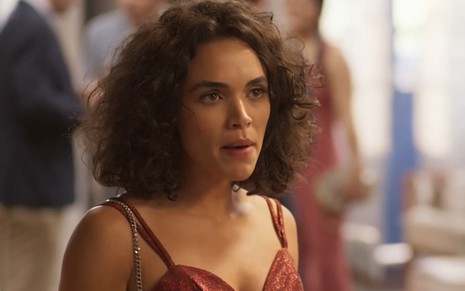 Giovana Cordeiro, caracterizada como Xaviera, tem a expressão debochada em cena de Mar do Sertão; ela usa uma maquiagem bem marcada e um vestido decotado