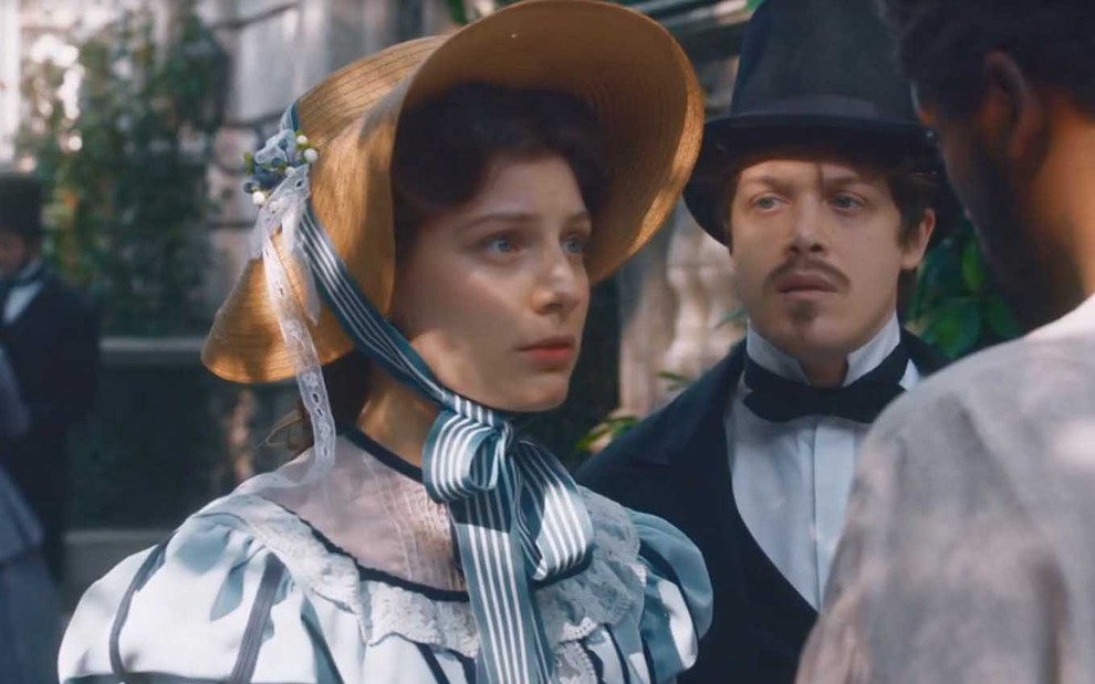 A atriz GIulia Gayoso com expressão de tristeza como a Isabel é observada por Daniel Torres, o Gastão, em cena de Nos Tempos do Imperador
