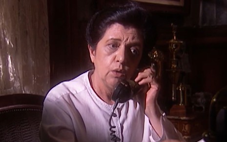 Walderez de Barros caracterizada como Judite; ela usa uma camisa branca e os cabelos presos num coque. O semblante está sério em cena de O Rei do Gado