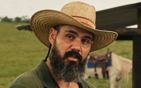 Juliano Cazarré grava cena com expressão séria, como Alcides em Pantanal