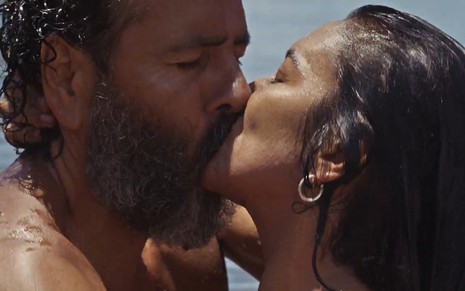 Marcos Palmeira, caracterizado como José Leôncio, e Dira Paes, a Filó, estão com o corpo molhado; eles se beijam intensamente em cena de Pantanal
