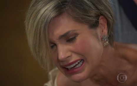 A atriz Flávia Alessandra grava cena da novela Salve-se Quem Puder simulando um pranto de dor, com os cabelos cobrindo parte do rosto