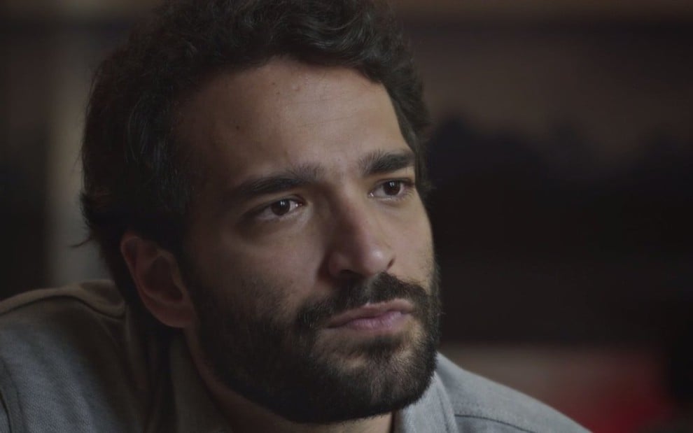 O ator Humberto Carrão em cena de Todas as Flores; ele tem barba e está em close como Rafael