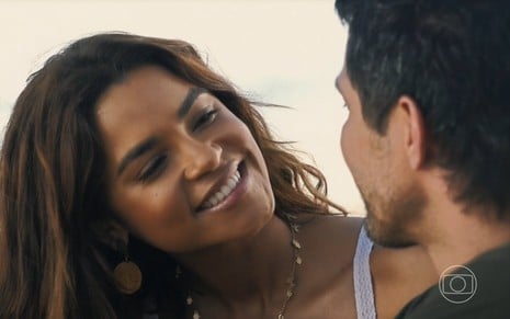 Lucy Alves olha para Romulo Estrela com sorriso no rosto em cena romântica da novela Travessia