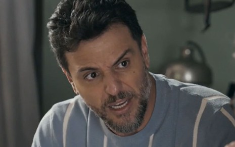 Rodrigo Lombardi caracterizado como Moretti; ator tem os olhos arregalados e a boca aberta em cena de Travessia