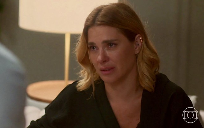 A atriz Carolina Dieckmann está com cara de choro em cena da novela Vai na Fé na qual usa camisa preta como Lumiar
