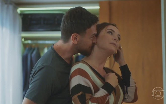 Emilio Dantas beija o pescoço de Regiane Alves em cena da novela Vai na Fé; eles estão caracterizados como Theo e Clara