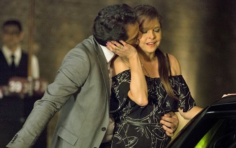 O ator Rodrigo Lombardi usa terno e gravata em cena de pegação de Verdades Secretas com Drica Moraes, que está de vestido escuro