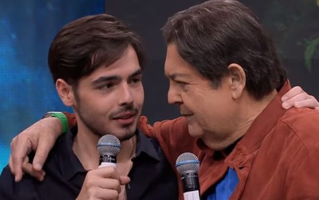 João Guilherme e Fausto Silva estão abraçados, em edição do Faustão na Band