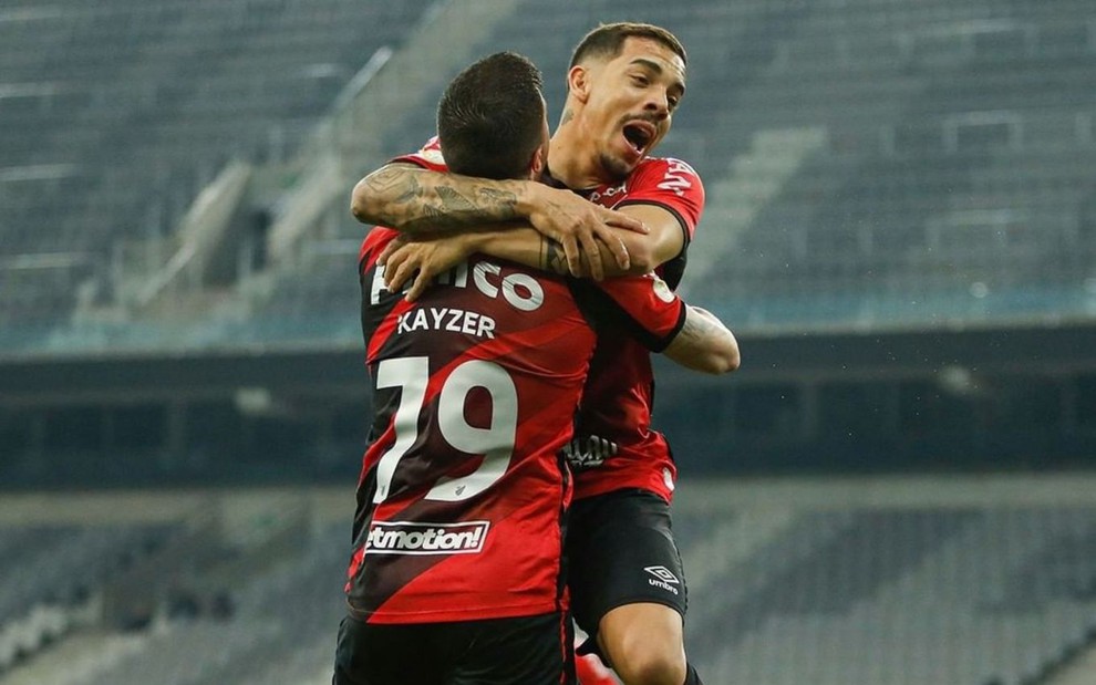 Dois jogadores do Athletico vibram e comemoraram um gol na Arena da Baixada, pelo Brasileirão
