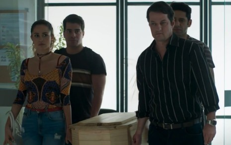 Os atores Nanda Costa, Thiago Martins, Marcelo Serrado e João Baldasserini carregam um caixão pequeno em cena de Pega Pega