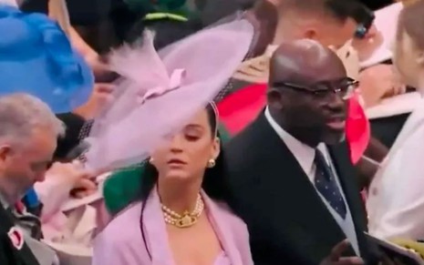 Katy Perry com um chapéu rosa, gigantesco, na coroação de Charles 3º