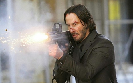 Keanu Reeves segurando arma em cena de John Wick - De Volta ao Jogo